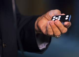 George Joseph shows off an opaque domino during a Courtroom Conversation at the National Museum of Organized Crime and Law Enforcement on Wednesday, May 21, 2014.  The MOB Museum is playing host for 