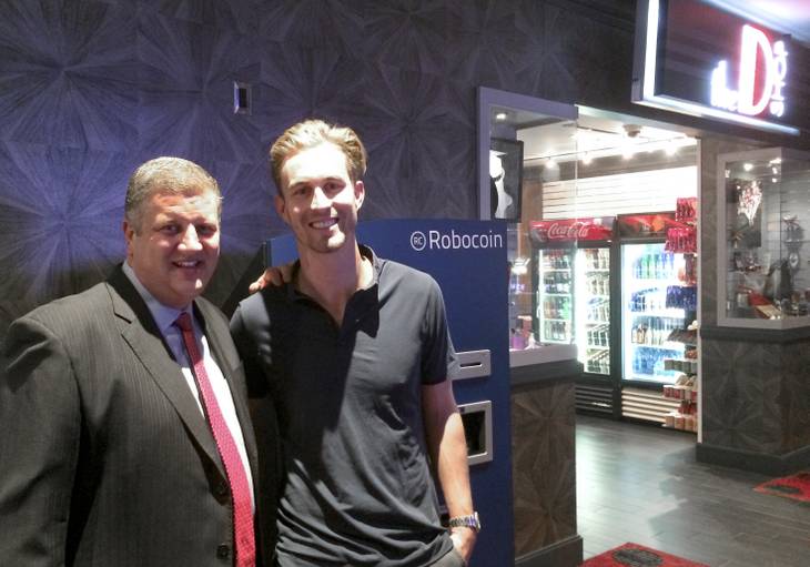 CEO of the D Derek Stevens, left, and Robocoin CEO Jordan Kelley stand next to a Bitcoin ATM, the first available at a casino property.