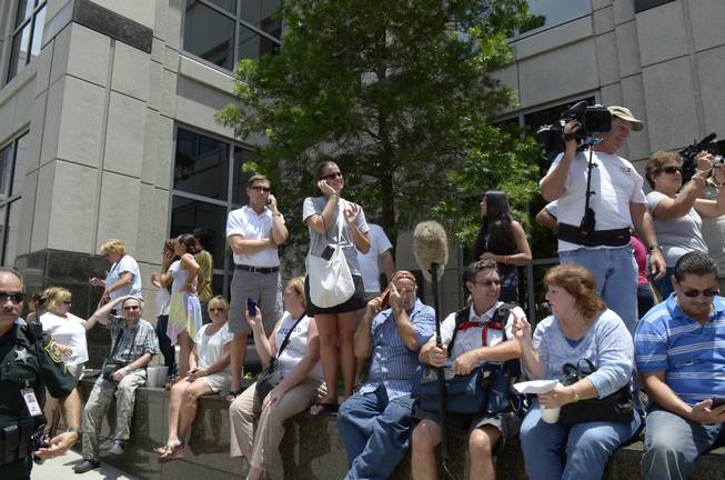 In this July 5, 2011 file photo, spectators wait outside the Orange County Courthouse to hear the announcement of the verdict in the Casey Anthony trial in Orlando, Fla. Media coverage of the Casey Anthony trial at the Orange County Courthouse in Orlando and the George Zimmerman trial in the nearby Seminole County Courthouse in Sanford has turned the local legal community into semi-celebrities.