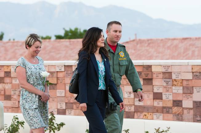 Family members of fallen officer LVMPD Search and Rescue Officer David VanBuskirk and Search and Rescue Officer Connell walk past the memorial wall where VanBuskirk's name will be added during the Southern Nevada Law Enforcement Memorial ceremony at Police Memorial Park in Las Vegas Thursday, May 22, 2014.