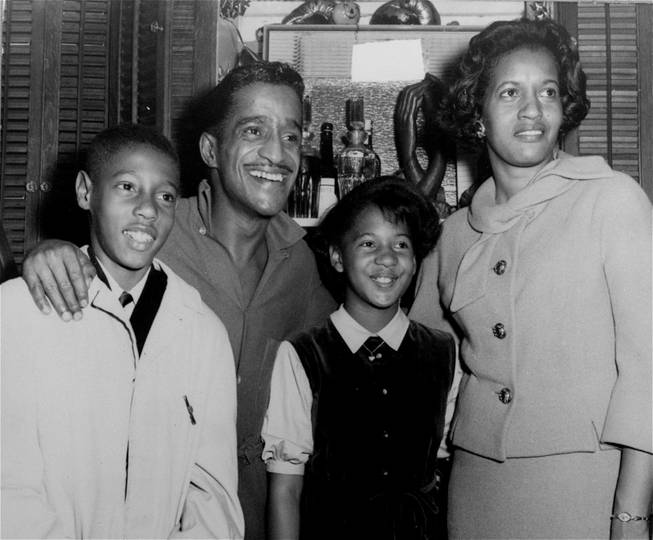 Entertainer and civil rights activist Sammy Davis, Mrs. Medgar Evers, widow of slain activist Medgar Evers, and her children Darrell and Reene, are all smiles in Sammy's dressing room backstage after Saturday's matinee of the musical "Golden Boy" at the Majestic Theatre, NYC, January 5, 1965.