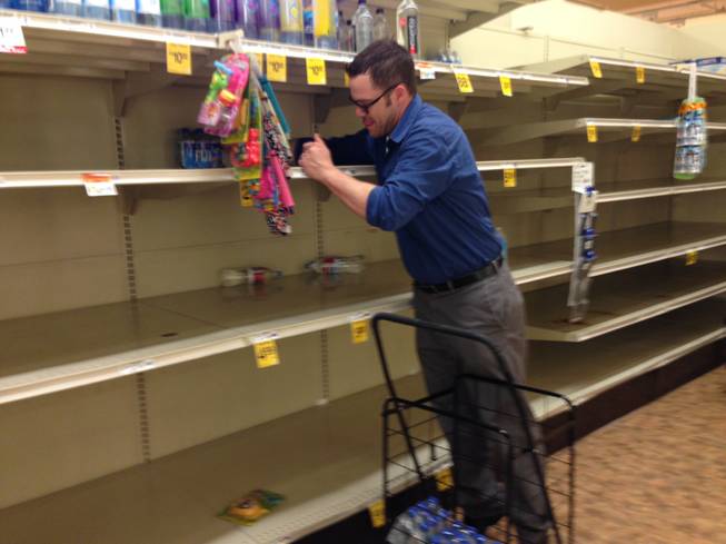 Matt Smith purchases some of the last bottled water available Friday, May 23, 2014, at a Safeway store in Portland, Ore. A citywide boil notice was issued Friday for Portland, after E. coli was detected in the water supply, causing a rush on bottled water.