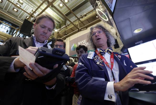 Trader Thomas McCauley, left, and specialist Donald Civitanova work on the floor of the New York Stock Exchange, Friday, May 23, 2014. Stocks inched higher early Friday in quiet trading ahead of the Memorial Day weekend.