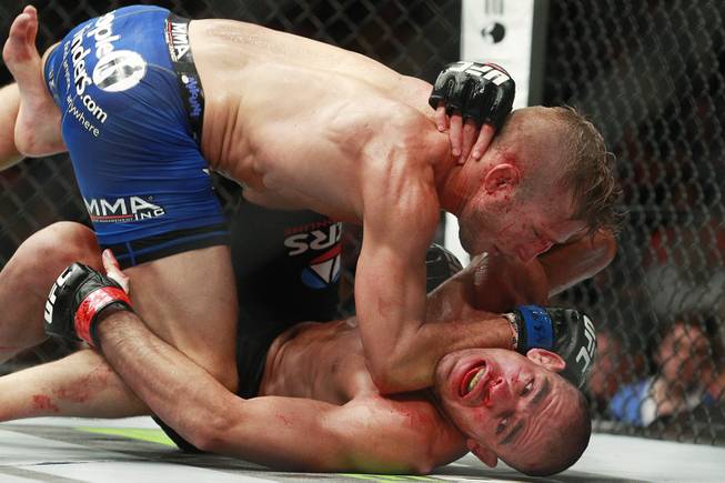 T.J. Dillashaw drops elbows on Renan Barao during their bantamweight title fight at UFC 173 on Saturday, May 24, 2014, at MGM Grand Garden Arena. Dillashaw won with a TKO in the fifth round.