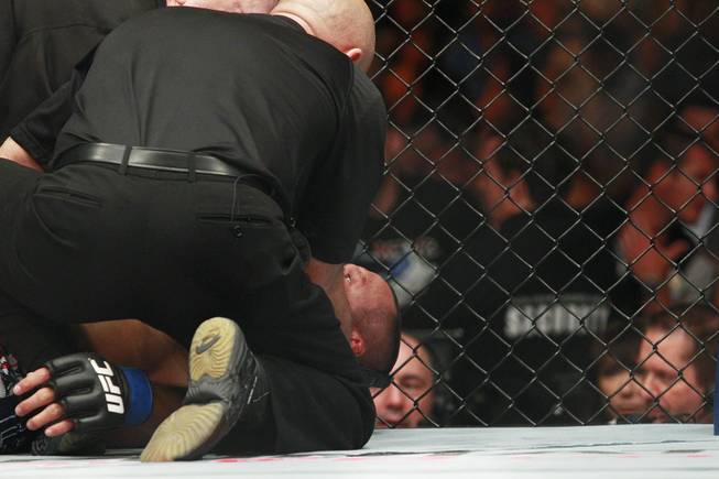 Dan Henderson is attended to after being choked out by Daniel Cormier during their fight at UFC 173 Saturday, May 24, 2014 at the MGM Grand Garden Arena. Cormier won with a rear naked choke in the third round.