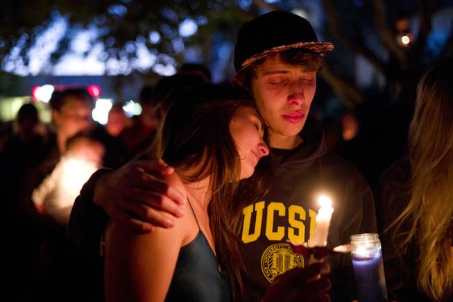 Two students comfort each other during a candlelight vigil held to honor the victims of Friday night's mass shooting on Saturday, May 24, 2014, in Isla Vista, Calif. Sheriff's officials said Elliot Rodger, 22, went on a rampage near the University of California, Santa Barbara, stabbing three people to death at his apartment before shooting and killing three more in a crime spree through a nearby neighborhood.