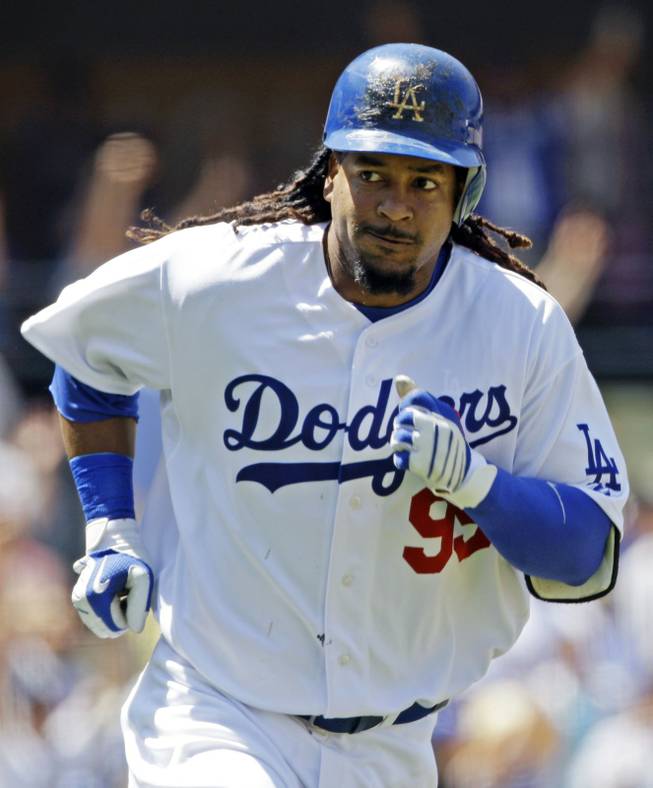 In this April 18, 2009, file photo, Los Angeles Dodgers' Manny Ramirez looks towards the visitor's dugout as he heads for first on his third-inning home run against the Colorado Rockies in a baseball game in Los Angeles. Ramirez signed a minor league deal with the Cubs on Sunday, May 25, 2014, and will be a player-coach at Triple-A Iowa after he gets some at-bats in extended spring training at the team's facility in Mesa, Ariz. 
