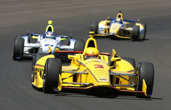 Helio Castroneves, of Brazil, leads JR Hildebrand, center, and Marco Andretti through the first turn during the Indianapolis 500 IndyCar auto race at the Indianapolis Motor Speedway in Indianapolis on Sunday, May 25, 2014. 