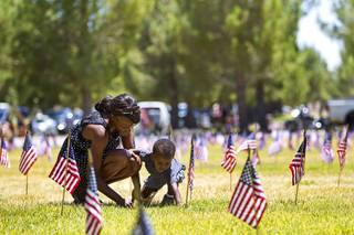 Teresa Brown and her son Keon, 2, visit the gravesite of Teresa's father Robert Brown, a Korean war veteran, before a Memorial Day ceremony at the Southern Nevada Veterans Memorial Cemetery in Boulder City Monday, May 26, 2014.