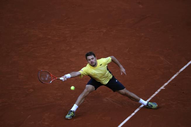 Switzerland's Stanislas Wawrinka returns the ball during the first round match of the French Open tennis tournament against Spain's Guillermo Garcia-Lopez at the Roland Garros stadium, in Paris, France, Monday, May 26, 2014.