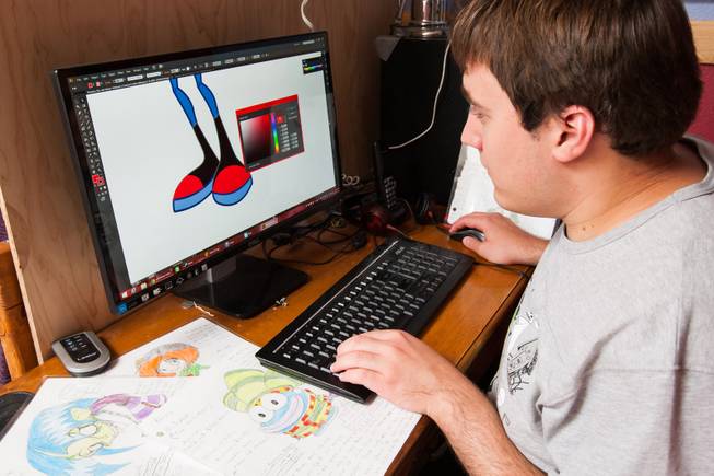 Author Ben Nelson, 20, who is autistic and has recently published his first book "Little Red Flying Hood," selects a color swatch as he creates the graphics for a new comic book while working at his home in Henderson May 23, 2014.
