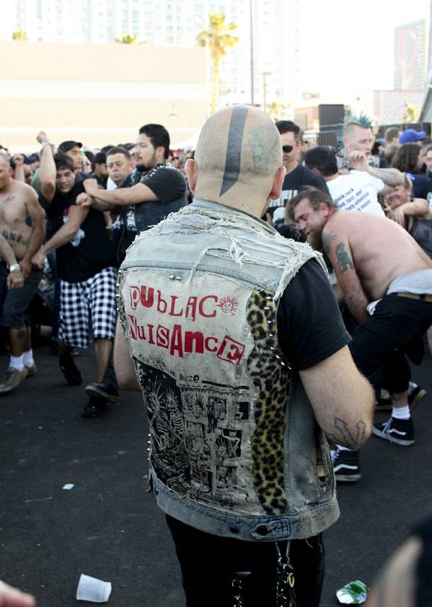 An onlooker watches festival goers take part in the mosh pit during SNFU's set at the Punk Rock Bowling & Music Festival Sunday, May 25, 2014.
