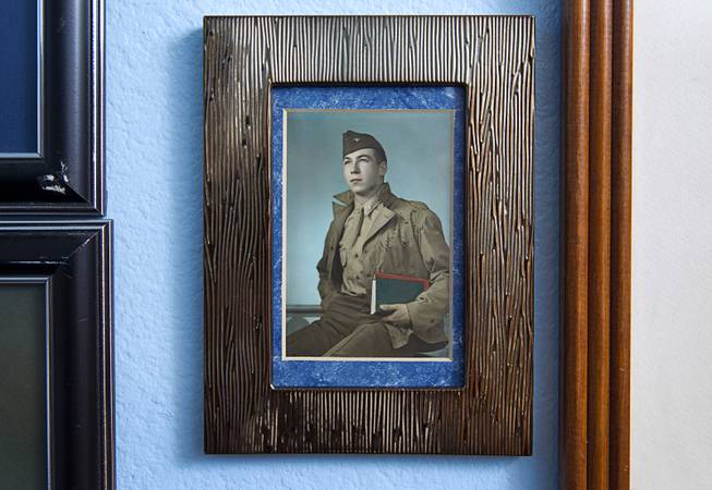 A 1943 photo showing a 19-year-old Davis B. Leonard hangs in Leonard's home in Henderson Wednesday, May 28, 2014. Leonard and Gaetano "Guy" Benza, another local World War II veteran, will receive the French Legion d'Honneur award on Friday. The award is the highest honor France bestows on its citizens and foreign nationals.