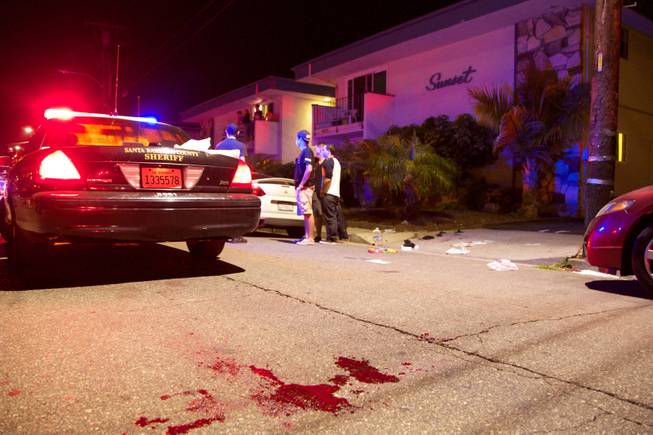 Police investigate the scene of a drive-by shooting that left seven people dead, including the attacker, and others wounded on Friday, May 23, 2014, in Isla Vista, Calif. 