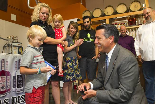 Brooks Forrest, 6, receives a "Governor's coin" from Nevada Governor Brian Sandoval at the Las Vegas Distillery in Henderson Thursday, May 29, 2014. Governor Sandoval helped fill the first bottle of "Nevada 150," a bourbon whiskey created for the Nevada sesquicentennial.