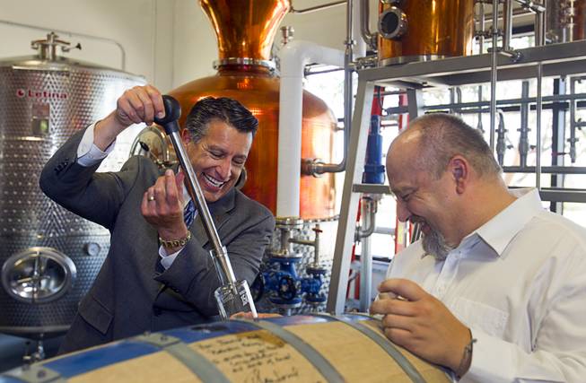 Nevada Governor Brian Sandoval, left, and distillery owner George Racz fill a bottle with whiskey after breaking open the "Governor's Barrel" at the Las Vegas Distillery in Henderson Thursday, May 29, 2014. Governor Sandoval helped fill the first bottle of "Nevada 150," a bourbon whiskey created for the Nevada sesquicentennial.
