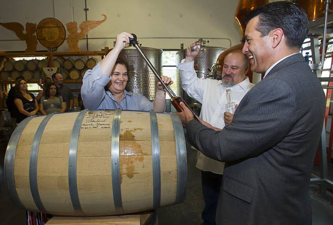 Distillery owners Katalin and George Racz fill a bottle of whiskey with Nevada Governor Brian Sandoval at the Las Vegas Distillery in Henderson Thursday, May 29, 2014. Governor Sandoval helped fill the first bottle of "Nevada 150," a bourbon whiskey created for the Nevada sesquicentennial.