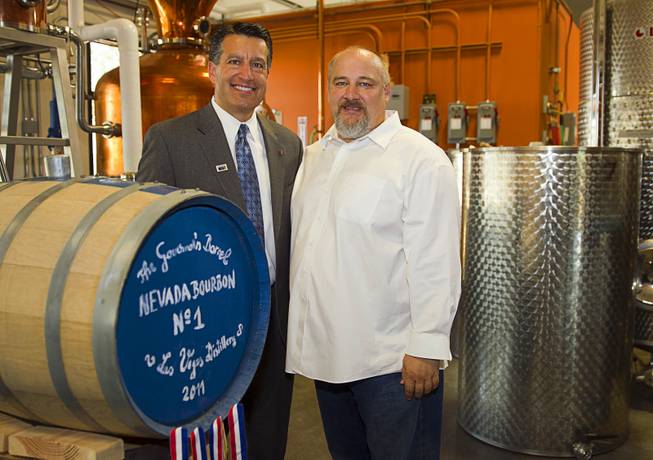Nevada Governor Brian Sandoval, left, poses with distillery owner George Racz at the Las Vegas Distillery in Henderson Thursday, May 29, 2014. Sandoval helped fill the first bottle of "Nevada 150," a bourbon whiskey created for the Nevada sesquicentennial.