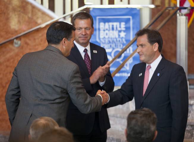 Governor Brian Sandoval shakes the hand of Lt. Governor Brian Krolicki as Jim Snyder looks on during the unveiling ceremony of the Nevada Sesquicentennial commemorative stamp at the Smith Center on Thursday, May 29, 2014.