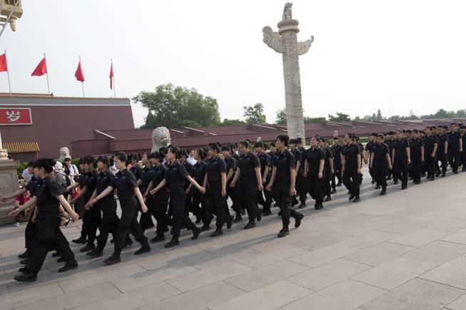 Female and male security guards march in front of Tiananmen Gate in Beijing Saturday, May 31, 2014. A quarter century after the Tiananmen Square pro-democracy movement’s suppression, China’s communist authorities oversee a raft of measures for muzzling dissent and preventing protests. They range from the sophisticated - extensive monitoring of online debate and control over media - to the relatively simple - routine harassment of government critics and maintenance of a massive domestic security force. (AP Photo/Alexander F. Yuan)