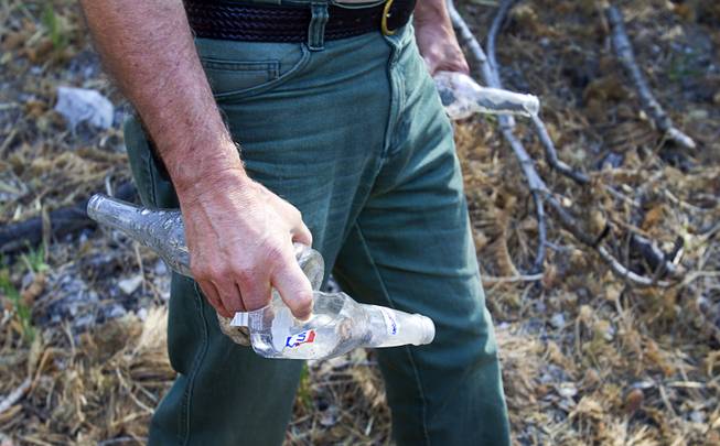 Randy Swick, center, USFS area manager, carries out garbage after touring an area near the Cathedral Rock Picnic Area on Mt. Charleston Tuesday, May 27, 2014. The mountain is showing signs of recovery, about one year after the Carpenter 1 Fire that scorched almost 28,000 acres in 2013.