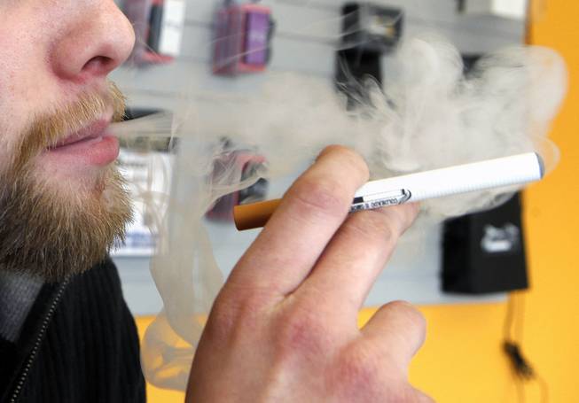 A sales associate demonstrates the use of a electronic cigarette and the smoke like vapor that comes from it in Aurora, Colo. on Wednesday, March 2, 2011. 