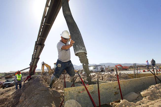 Francisco Bernal pours piers for patio columns while working on a KB Homes project at Inspirada in Henderson Tuesday, June 3, 2014. A number of formerly stalled or financially troubled master-planned communities are now back in business, with developers building and selling homes.