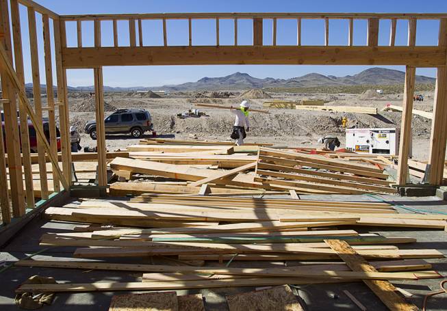 Workers frame a house at a KB Homes project at Inspirada in Henderson Tuesday, June 3, 2014. A number of formerly stalled or financially troubled master-planned communities are now back in business, with developers building and selling homes.