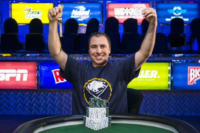 Jonathan Dimmig holds his World Series of Poker bracelet and winning hand at the Rio after emerging victorious in the 2014 Millionaire Maker tournament for $1.3 million.