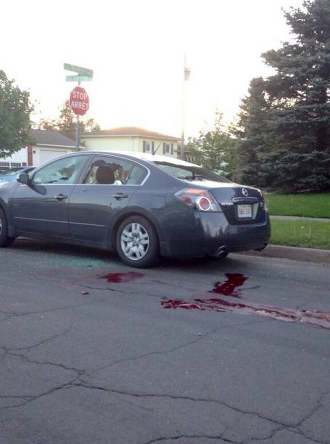 A car sits on a road with it's windows shot out and blood on the ground in Moncton, New Brunswick on Wednesday, June 4, 2014. The Royal Canadian Mounted Police says three of its officers were killed in Moncton, New Brunswick by a man armed with guns and two other officers were injured as the Mounties conducted a manhunt across the city's north end on Wednesday night for the shooter. 