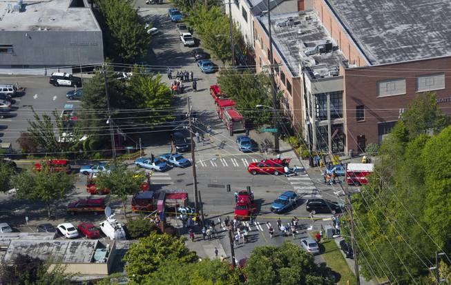 In an aerial view, authorities and other emergency responders gather near Otto Miller Hall, upper left, at Seattle Pacific University on Thursday, June 5, 2014, in Seattle. Police say a university student on Thursday disarmed a lone gunman who entered a building and shot four people. A hospital spokeswoman says one man has died and three other people are injured, one critically. (AP Photo/The Seattle Times, Ellen M. Banner) SEATTLE OUT   USA TODAY OUT  MAGS OUT; NO SALES; TV OUT; MANDATORY CREDIT TO BOTH THE SEATTLE TIMES AND THE PHOTOGRAPHER