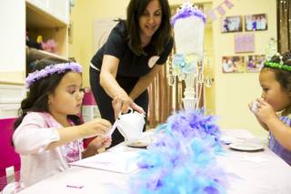 Laura Heller, owner of Rock the Tea, pours tea for her party guests Mia, at left, and Reece, at right, Tuesday June 3, 2014. Rock the Tea is a themed party-hosting service for young girls.