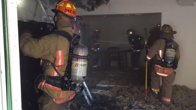 In an image captured from a Las Vegas Fire &amp; Rescue video, firefighters work in the aftermath of a fire that started about 5 a.m. Friday, June 6, 2014, in a house in the 1900 block of Wengert Avenue. Officials said six people were taken to University Medical Center with smoke inhalation.