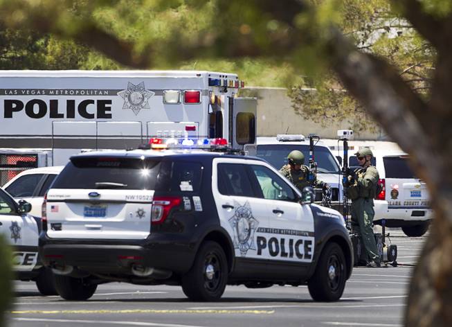 Metro Police officers set up equipment in the parking lot of a Wal-Mart on Nellis Boulevard Sunday, June 8, 2014. Two suspects shot two Metro Police officers in a nearby pizza shop then fled to the Wal-Mart where they shot and killed another person, police said. Both officers died of their injuries.