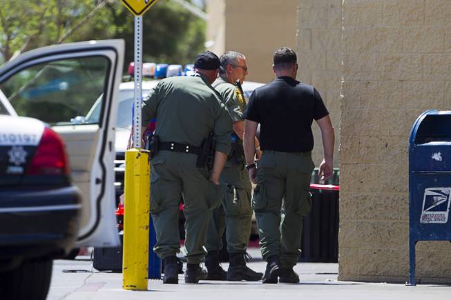 Metro Police officers are shown outside a Wal-Mart on Nellis Boulevard Sunday, June 8, 2014. Two suspects shot two Metro Police officers in a nearby pizza shop then fled to the Wal-Mart where they shot and killed another person, police said. Both officers died of their injuries.