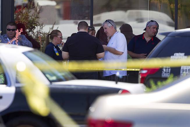Wal-Mart employees wait near a Metro Police command center Sunday, June 8, 2014. Two suspects shot two Metro Police officers in a nearby pizza shop then fled to the Wal-Mart where they shot and killed another person, police said. Both officers died of their injuries.