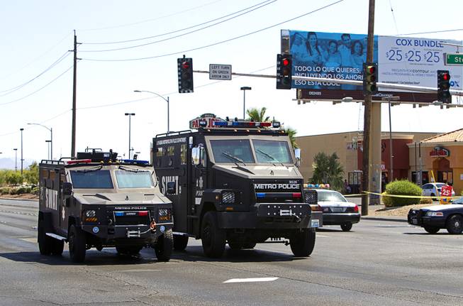 Metro Police SWAT vehicles leave the scene of a Wal-Mart on Nellis Boulevard Sunday, June 8, 2014. Two suspects shot two Metro Police officers in a nearby pizza shop then fled to the Wal-Mart where they shot and killed another person, police said. Both officers died of their injuries.