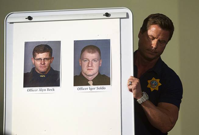 A Metro Police officer brings out photos of slain Metro Police officers Alyn Beck, left, and Igor Soldo during a news conference at Metro headquarters following the death of two officers and a citizen Sunday, June 8, 2014. Two suspects shot the two Metro Police officers in the pizza shop then fled to a nearby Wal-Mart where they shot and killed another person, police said.