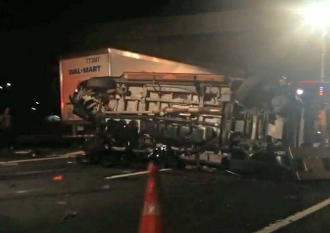 In this image from video the limousine bus carrying Tracy Morgan and six other people lies on its side early Saturday morning June 7, 2014, on the New Jersey Turnpike. Morgan remained hospitalized as state and federal officials continued their investigation of the six-vehicle crash on the New Jersey Turnpike that took the life of a Morgan friend and left two others seriously injured, authorities say.
