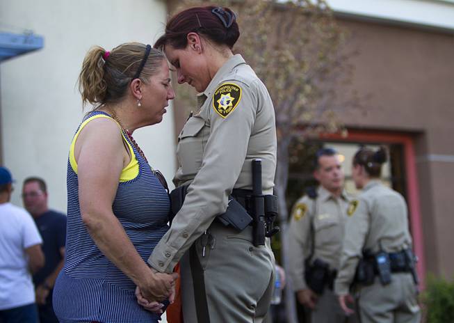 Cheri Rasmussen, left, prays with Metro Police Lt. Roxanne McDarris in front of CiCi's Pizza during a community vigil for slain Metro Police officers Monday,, Nevada June 9, 2014. Officers Alyn Beck, 41, and Igor Soldo, 31, were ambushed and killed in the restaurant while they were eating lunch on June 8.