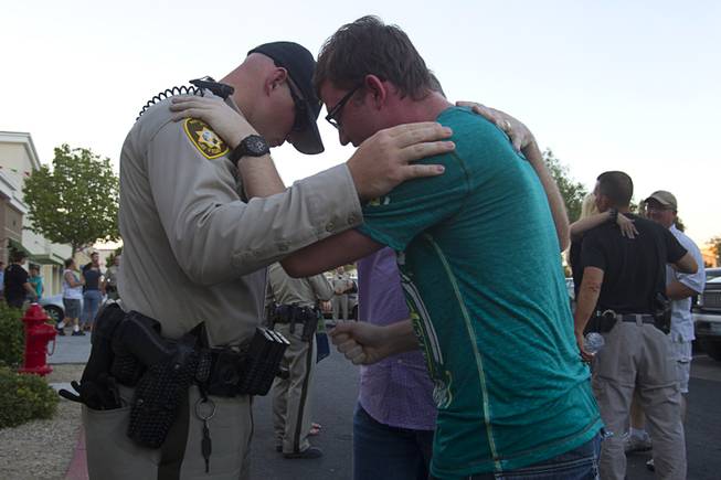 Metro Police officer Harrison Porter, left, prays with Ryan Rasmussen during a community vigil for slain Metro Police officers at CiCi's Pizza Monday,, Nevada June 9, 2014. Officers Alyn Beck, 41, and Igor Soldo, 31, were ambushed and killed in the restaurant while they were eating lunch on June 8.