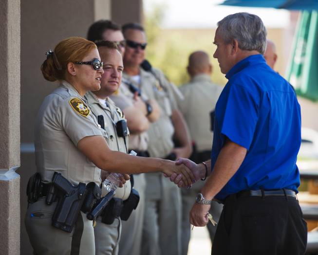 Metro Police officers are consoled by Mike Haskins as they gather across from CiCi's Pizza restaurant in Las Vegas to honor their fallen brothers on Monday, June 9, 2014.