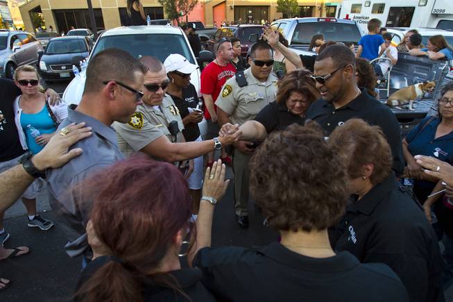 Metro Police officers, family and supporters pray to honor slain officers Alyn Beck and Igor Soldo following a candlelight vigil outside of CiCi's Pizza restaurant on Monday, June 9, 2014.