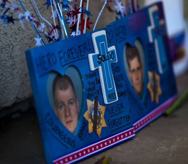 A memorial to slain Metro Police officers Alyn Beck and Igor Soldo grows as community members  gather for a candlelight vigil in their honor outside of CiCi's Pizza restaurant on Monday, June 9, 2014.