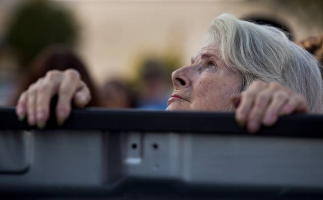 A woman looks to the sky as community members come together for a candlelight vigil to show support for two Metro Police officers who were slain on Sunday and others who have passed away in the line of duty on Monday, June 9, 2014.