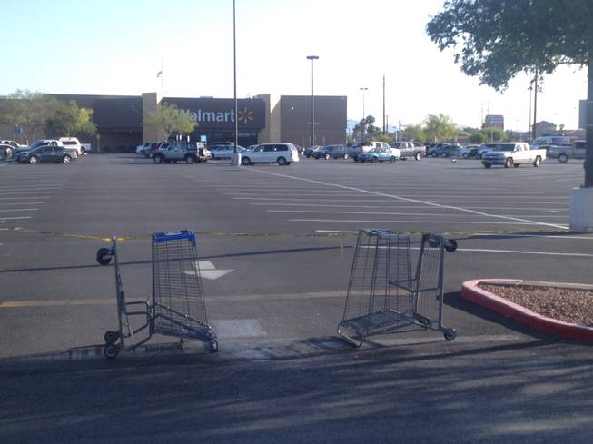 Upturned carts and police tape block a parking lot entrance to a Wal-Mart store at 201 N. Nellis on Monday, June 6, 2014, a day after a shooting that left five people dead, including two Metro Police officers who were shot at a nearby pizza restaurant. One person was shot and killed at the Wal-Mart, where the two shooters also died.

