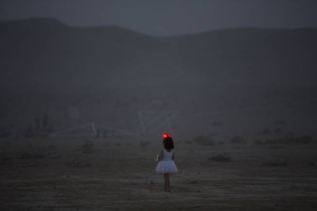 In this photo taken Wednesday, June 4, 2014, a young Israeli girl walks in the playa during Israelis first Midburn festival in the desert near the Israeli kibbutz of Sde Boker.