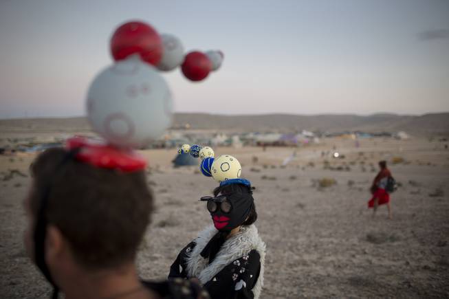 In this photo taken Friday, June 6, 2014, Israelis in costumes walk around the playa during Israelis first Midburn festival in the desert near the Israeli kibbutz of Sde Boker.