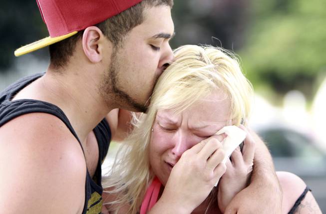 Two people comfort each other as they await word about the safety of students after a shooting at Reynolds High School Tuesday, June 10, 2014, in Troutdale, Ore. A gunman killed a student at the high school east of Portland Tuesday and the shooter is also dead, police said.