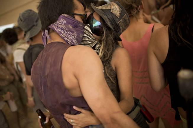 In this photo taken Thursday, June 5, 2014, Israelis kiss at a party during Israelis first Midburn festival in the desert near the Israeli kibbutz of Sde Boker.